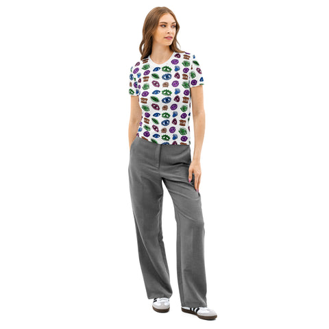 Woman wearing an All Eyes On Me Print Tee featuring colorful eye and celestial symbols all over a white cotton fabric paired with gray wide-leg pants and sneakers.