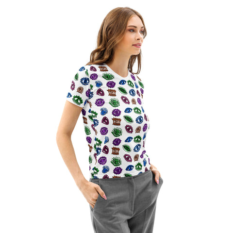Woman wearing the All Eyes On Me Print Tee, a white cotton crew neck shirt with a colorful all-over print of various symbolic eyes and mystical motifs, styled with gray pants.