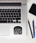 As Above, So Below Sticker (B&W) featuring intricate black and white celestial and occult-inspired design on durable high-opacity vinyl, placed on a laptop corner next to pencil, pen, and phone.