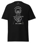 Black heavyweight fabric tee featuring a detailed white graphic of a mystical cat with snakes and radiant halo above, with the text "In a world full of Eves... Be a Lilith" on the front, titled Be a Lilith Tee.