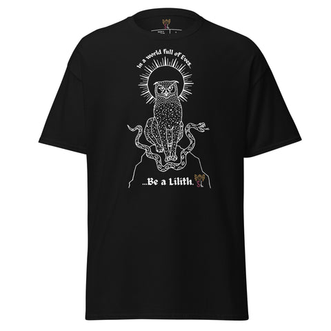 Black heavyweight fabric tee featuring a detailed white graphic of a mystical cat with snakes and radiant halo above, with the text "In a world full of Eves... Be a Lilith" on the front, titled Be a Lilith Tee.