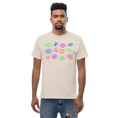 Man wearing an off-white premium heavyweight fabric "All Eyes On Me Tee" featuring colorful abstract eye designs in blue, green, and pink across the chest, styled in a casual look with ripped denim jeans.