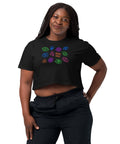 Woman wearing a black "All Eyes on Me Crop Top" featuring colorful, mystical eye symbols in a relaxed fit with cropped length, styled with black pants.