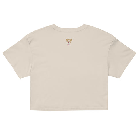Back view of a cream-colored All Eyes on Me Crop Top made from 100% combed cotton, featuring a relaxed fit, cropped length, and a small decorative golden design near the neckline.