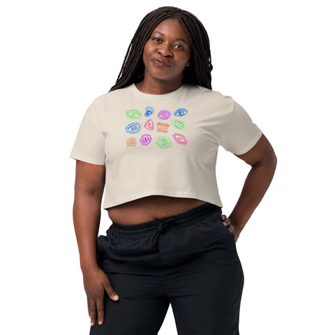 Woman wearing a relaxed fit, 100% combed cotton All Eyes on Me Crop Top with colorful eye and symbolic designs on the front, paired with black pants.