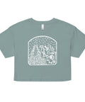 As Above, So Below Crop Top (White) in soft, lightweight combed cotton with a relaxed, cropped fit featuring a mystical white graphic of stars and flowing lines on a muted sage green background.