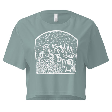 As Above, So Below Crop Top (White) in soft combed cotton with a relaxed fit, featuring a mystical white celestial design on a muted sage green background.